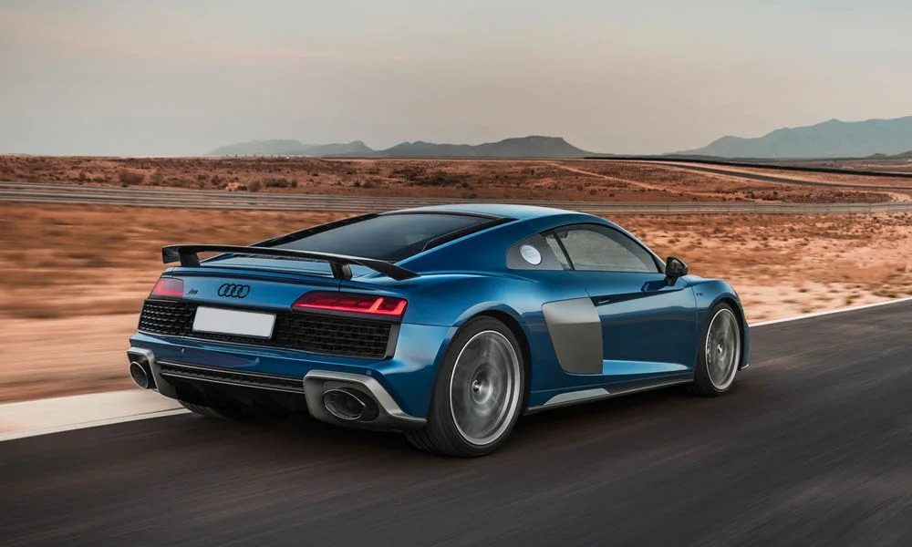 Фото Audi R8 (2024) — вид сзади, фото 11. Линия крыши, стойки и задняя дверь в синем исполнении. Насадки выхлопа или их имитация внизу бампера различают версии Audi R8 (2024) — вид сзади, фото 11