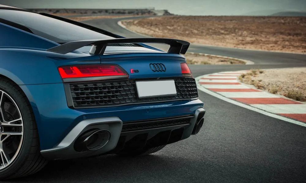Фото Audi R8 (2024) — вид сзади, фото 12. Корма в синем цвете: графика фонарей и пластика пятой двери. Насадки выхлопа или их имитация внизу бампера различают версии Audi R8 (2024) — вид сзади, фото 12