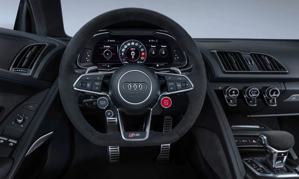 Фото Audi R8 (2024) — руль. Обшивка обода и компоновка спиц крупным планом. Клавиши на спицах управляют медиа, круизом и ассистентами — руки остаются на руле Audi R8 (2024) — руль