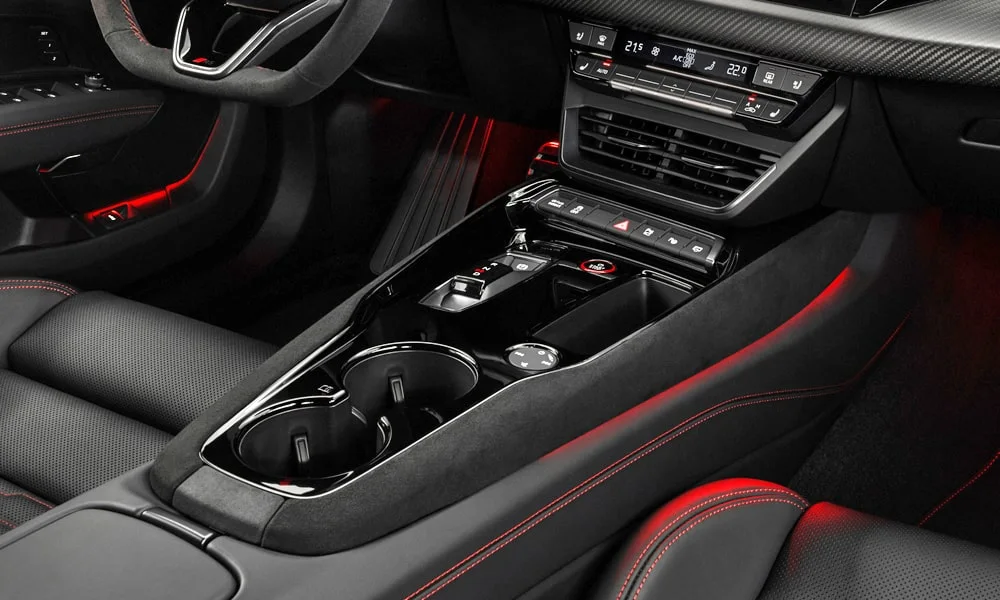 Фото Audi RS e-tron GT (2024) — центральная консоль. Бокс консоли открыт: организация хранения между креслами. Прорезиненное дно ниш удерживает мелочи в поворотах Audi RS e-tron GT (2024) — центральная консоль