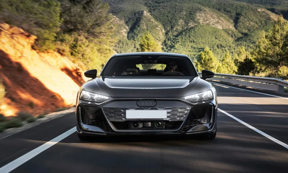 Фото Audi RS e-tron GT (2024) — вид спереди, фото 4. Анфас: пропорции капота, посадка кузова и графика ходовых огней. Дневные ходовые огни включаются автоматически с запуском Audi RS e-tron GT (2024) — вид спереди, фото 4