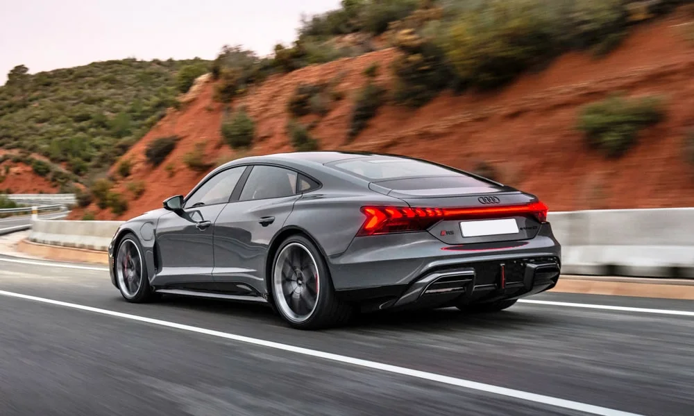 Фото Audi RS e-tron GT (2024) — вид сзади, фото 4. Корма в сером цвете: графика фонарей и пластика пятой двери. Насадки выхлопа или их имитация внизу бампера различают версии Audi RS e-tron GT (2024) — вид сзади, фото 4