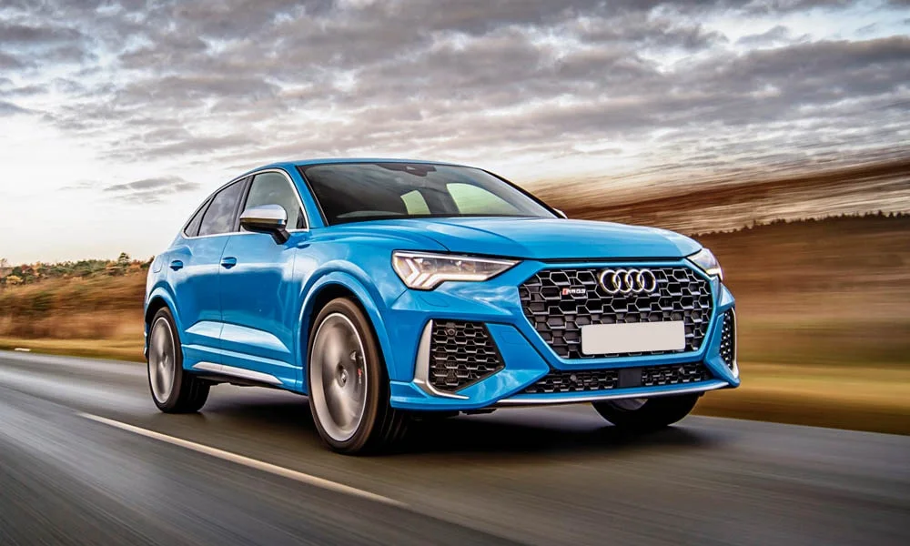 Фото Audi RS Q3 Sportback (2024) — вид спереди, фото 4. Передок в синем исполнении — крупная светотехника и выразительный бампер. Дневные ходовые огни включаются автоматически с запуском Audi RS Q3 Sportback (2024) — вид спереди, фото 4