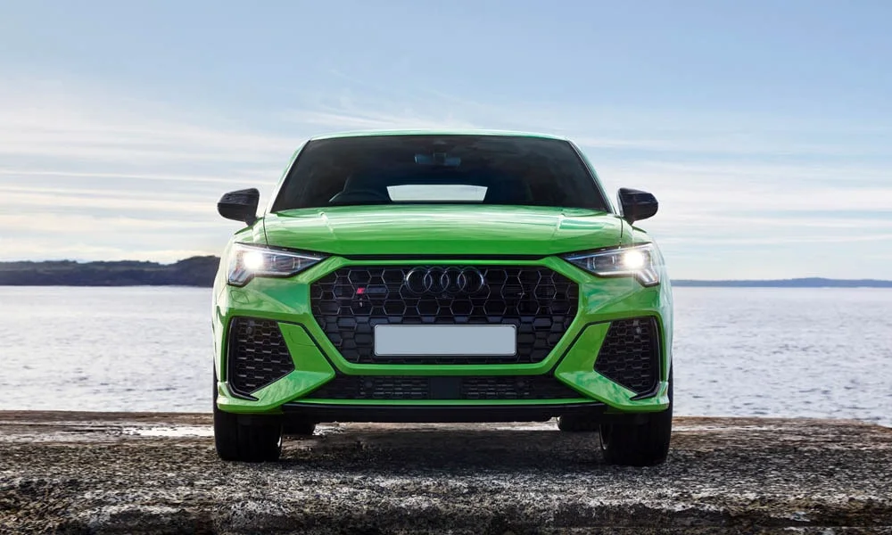 Фото Audi RS Q3 Sportback (2024) — вид спереди, фото 6. Передок в зелёном исполнении — крупная светотехника и выразительный бампер. Дневные ходовые огни включаются автоматически с запуском Audi RS Q3 Sportback (2024) — вид спереди, фото 6