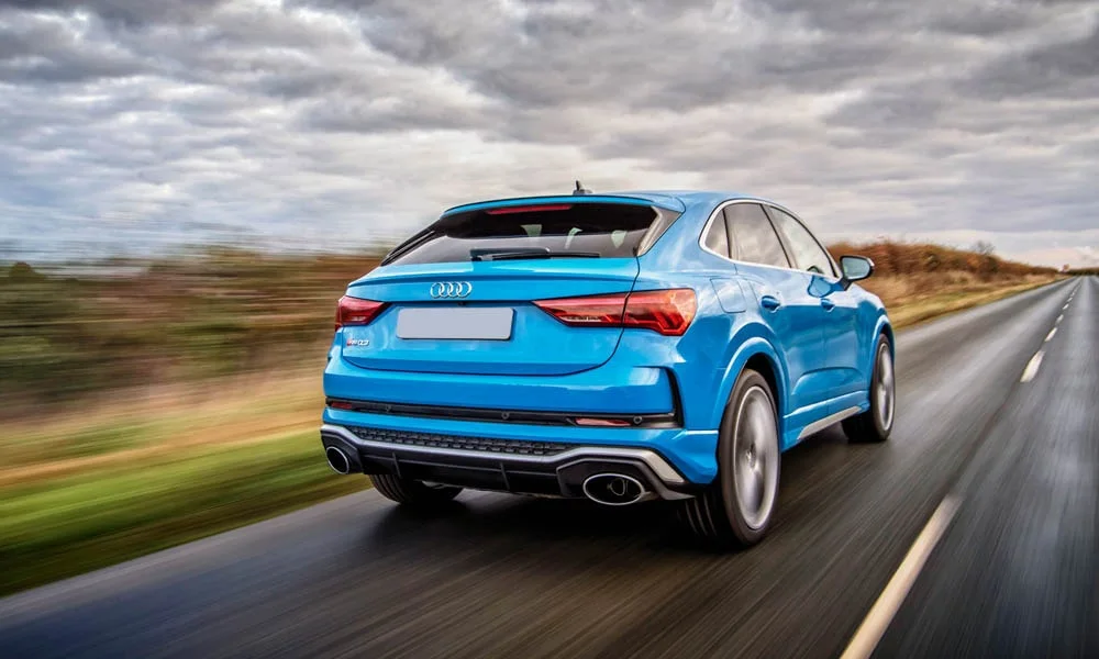 Фото Audi RS Q3 Sportback (2024) — вид сзади, фото 4. Корма в синем цвете: графика фонарей и пластика пятой двери. Светодиодная полоса или раздельные секции — задняя оптика стала главным украшением кормы Audi RS Q3 Sportback (2024) — вид сзади, фото 4