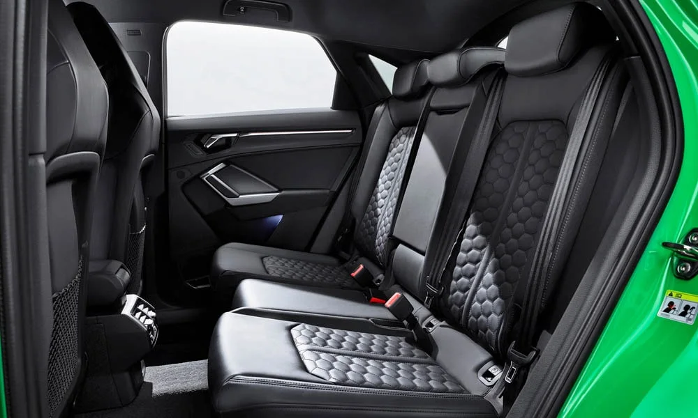 Фото Audi RS Q3 Sportback (2024) — задние сиденья. Посадка второго ряда: подголовники и подлокотник. Крепления ISOFIX для детских кресел — в основании спинки Audi RS Q3 Sportback (2024) — задние сиденья