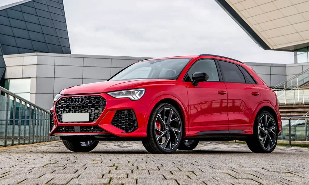 Фото Audi RS Q3 (2024) — вид спереди, фото 6. Кузов в красном цвете: рисунок оптики и решётки задаёт узнаваемое «лицо» модели Audi RS Q3 (2024) — вид спереди, фото 6