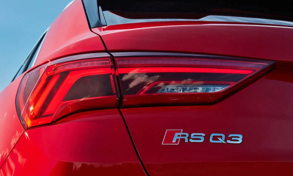 Фото Audi RS Q3 (2024) — вид сзади, фото 5. Корма в красном цвете: графика фонарей и пластика пятой двери. Насадки выхлопа или их имитация внизу бампера различают версии Audi RS Q3 (2024) — вид сзади, фото 5