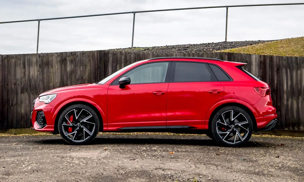Фото Audi RS Q3 (2024) — вид сбоку, фото 3. Красный кузов в профиль — пропорции, высота посадки и дизайн дисков Audi RS Q3 (2024) — вид сбоку, фото 3