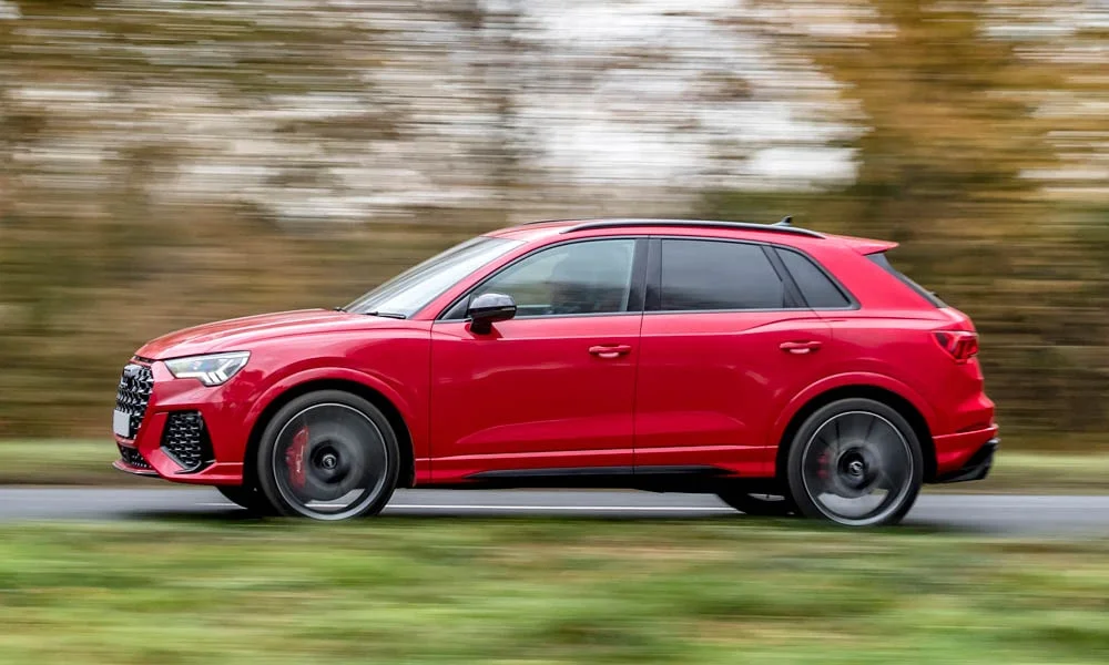 Фото Audi RS Q3 (2024) — вид сбоку, фото 5. Красный кузов в профиль — пропорции, высота посадки и дизайн дисков. Длинная база — простор второго ряда; короткие свесы упрощают парковку Audi RS Q3 (2024) — вид сбоку, фото 5