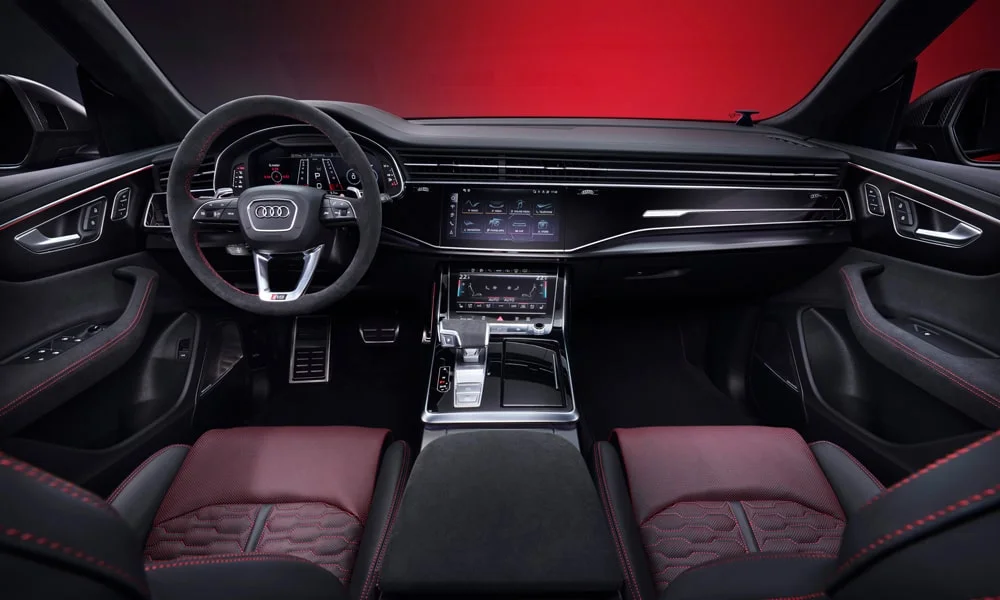 Фото Audi RS Q8 (2024) — передняя панель. Передняя панель в красно-чёрной отделке: расположение экранов и дефлекторов. Мягкие материалы верхнего яруса и вставки задают уровень интерьера Audi RS Q8 (2024) — передняя панель