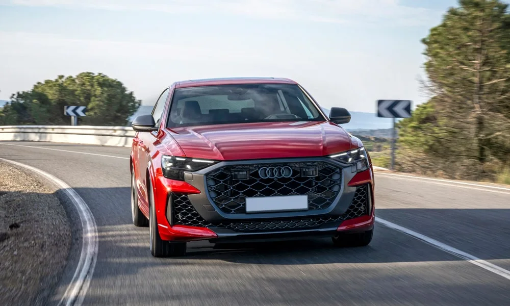 Фото Audi RS Q8 (2024) — вид спереди, фото 5. Передок в красном исполнении — крупная светотехника и выразительный бампер. Дневные ходовые огни включаются автоматически с запуском Audi RS Q8 (2024) — вид спереди, фото 5