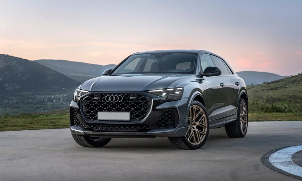 Фото Audi RS Q8 (2024) — вид спереди, фото 10. Серый кузов, строгая симметрия оптики — базовый ракурс знакомства с дизайном. Дневные ходовые огни включаются автоматически с запуском Audi RS Q8 (2024) — вид спереди, фото 10