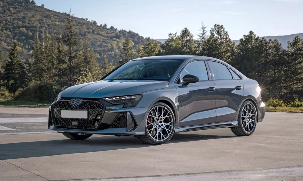 Фото Audi RS3 (2022) — вид спереди, фото 5. Кузов в сером цвете: рисунок оптики и решётки задаёт узнаваемое «лицо» модели. Дневные ходовые огни включаются автоматически с запуском Audi RS3 (2022) — вид спереди, фото 5