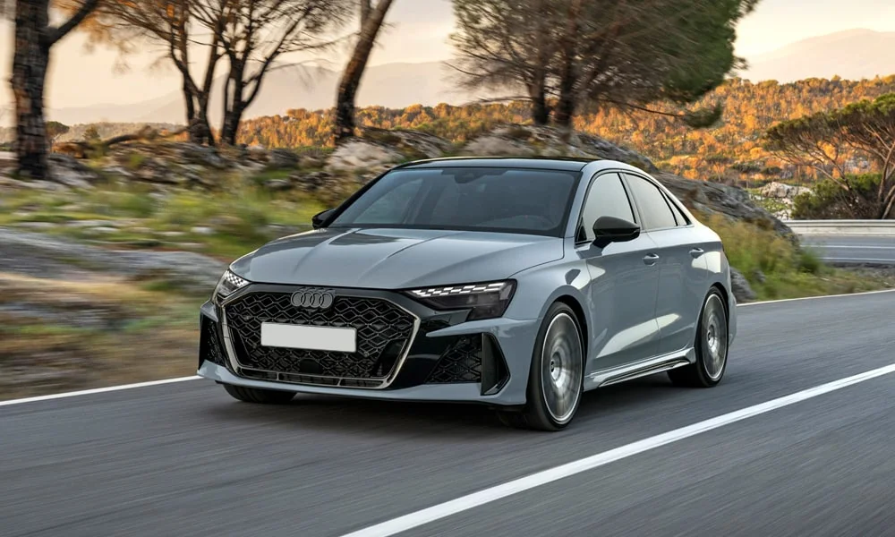 Фото Audi RS3 (2022) — вид спереди, фото 7. Кузов в сером цвете: рисунок оптики и решётки задаёт узнаваемое «лицо» модели Audi RS3 (2022) — вид спереди, фото 7