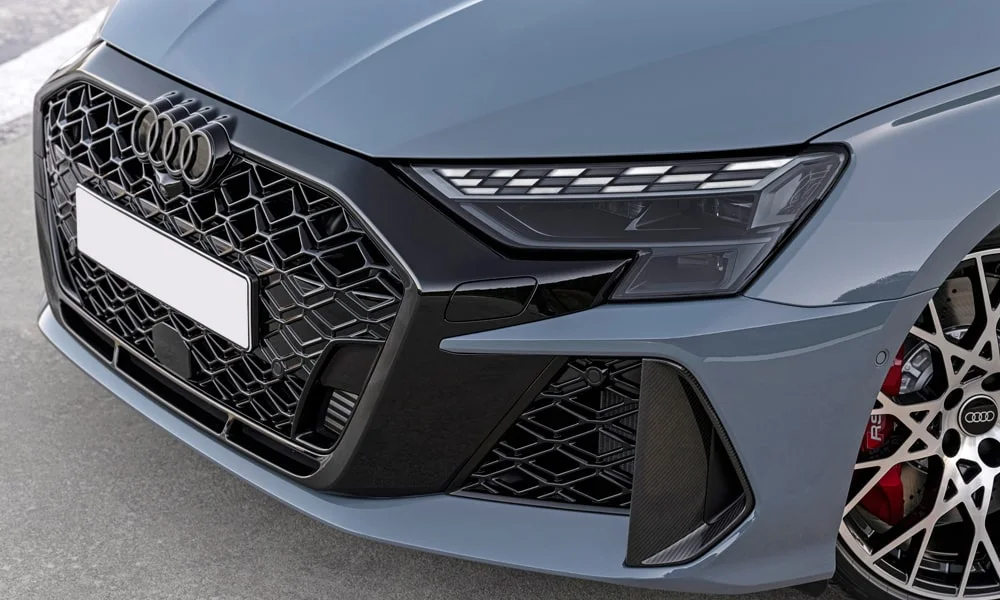 Фото Audi RS3 (2022) — решётка радиатора. Фирменный рисунок облицовки — визитная карточка марки. Активные жалюзи за решёткой закрываются на трассе ради аэродинамики — есть у ряда моделей Audi RS3 (2022) — решётка радиатора