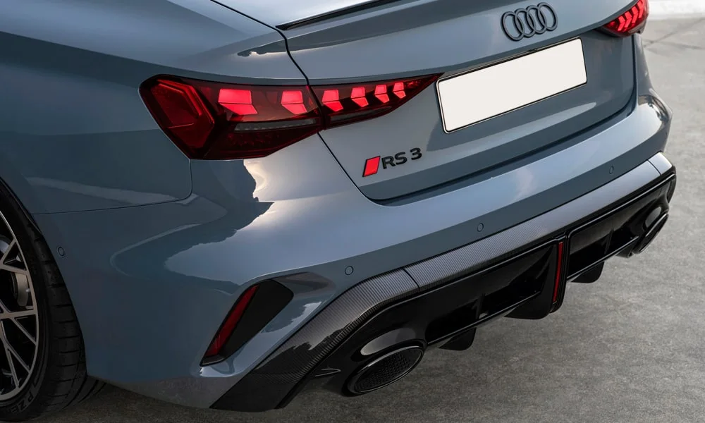 Фото Audi RS3 (2022) — вид сзади, фото 3. Линия крыши, стойки и задняя дверь в сером исполнении. Светодиодная полоса или раздельные секции — задняя оптика стала главным украшением кормы Audi RS3 (2022) — вид сзади, фото 3