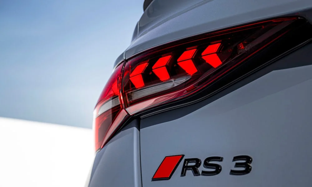 Фото Audi RS3 (2022) — задние фонари. Рассеиватель фонаря вблизи: компоновка секций габарита, стопа и поворотника. Динамические поворотники с бегущей индикацией встречаются в старших комплектациях Audi RS3 (2022) — задние фонари