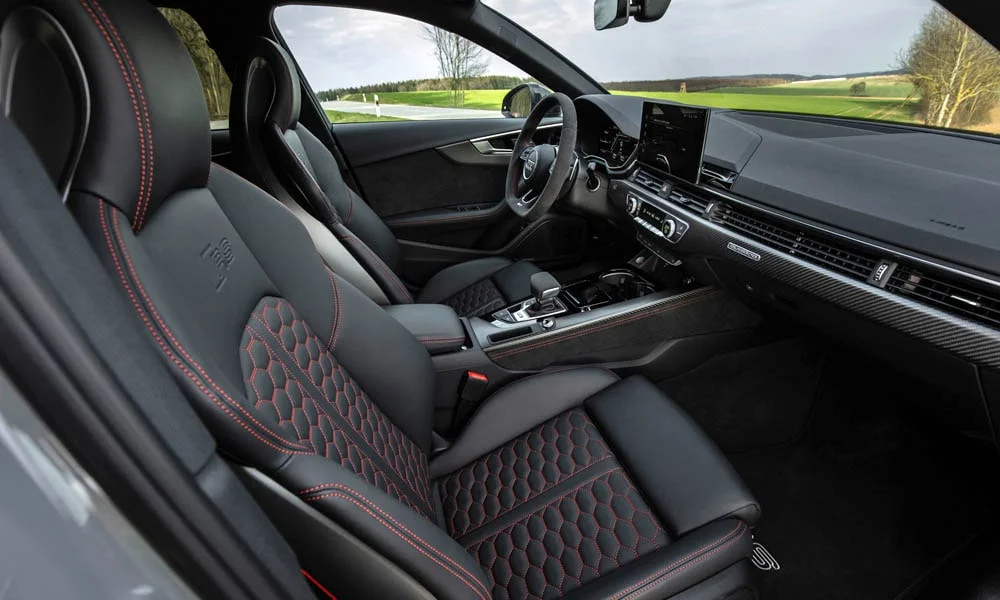 Фото Audi RS4 Avant — интерьер, фото 2. Общий план салона: посадка, материалы и организация пространства в красно-чёрной гамме. Светлая гамма зрительно расширяет салон, тёмная — практичнее в уходе Audi RS4 Avant — интерьер, фото 2