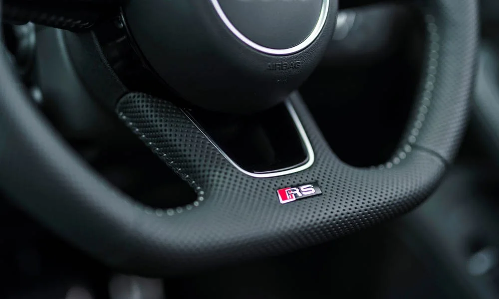 Фото Audi RS4 Avant — руль, фото 3. Обшивка обода и компоновка спиц крупным планом. Клавиши на спицах управляют медиа, круизом и ассистентами — руки остаются на руле Audi RS4 Avant — руль, фото 3