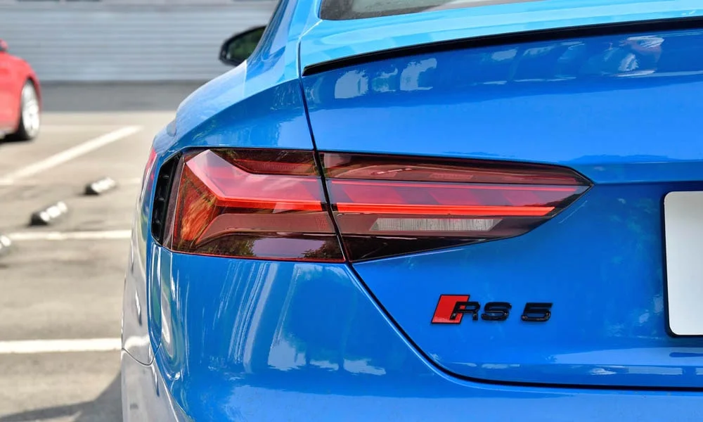 Фото Audi RS5 — вид сзади, фото 4. Линия крыши, стойки и задняя дверь в синем исполнении. Насадки выхлопа или их имитация внизу бампера различают версии Audi RS5 — вид сзади, фото 4