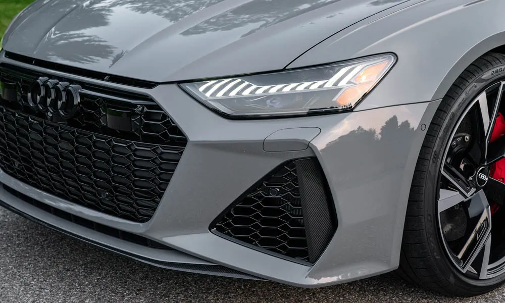 Фото Audi RS6 Avant — вид спереди, фото 5. Серый кузов, строгая симметрия оптики — базовый ракурс знакомства с дизайном. Рисунок ходовых огней — подпись модели, по нему её узнают в потоке Audi RS6 Avant — вид спереди, фото 5