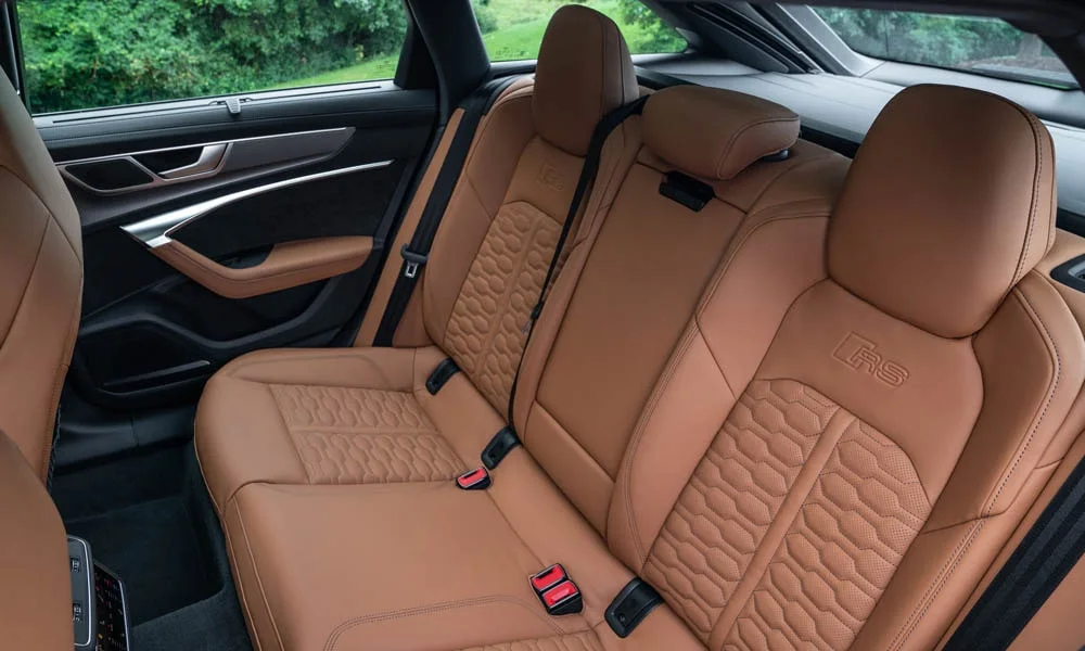 Фото Audi RS6 Avant — задние сиденья. Второй ряд: профиль дивана, подголовники и обивка из перфорированной коже Audi RS6 Avant — задние сиденья