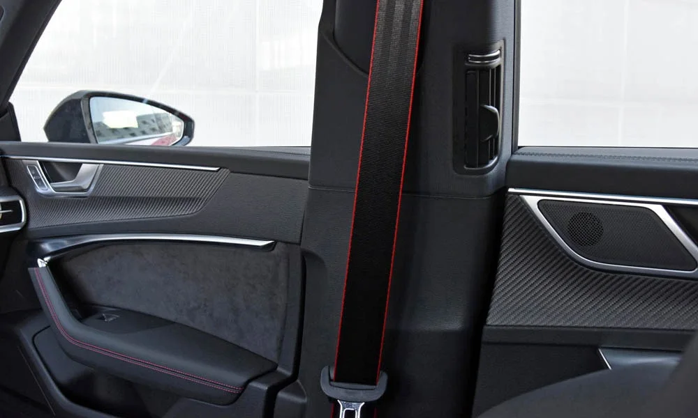Фото Audi RS7 Sportback — дверная карта. Дверная карта в красно-чёрной отделке: подлокотник, динамик и блок стеклоподъёмников. Решётка динамика в двери — часть штатной акустики Audi RS7 Sportback — дверная карта