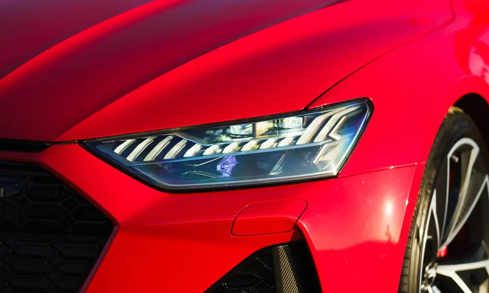 Фото Audi RS7 Sportback — вид спереди, фото 4. Передок в красном исполнении — крупная светотехника и выразительный бампер. Рисунок ходовых огней — подпись модели, по нему её узнают в потоке Audi RS7 Sportback — вид спереди, фото 4