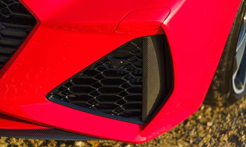 Фото Audi RS7 Sportback — вид спереди, фото 5. Кузов в красном цвете: рисунок оптики и решётки задаёт узнаваемое «лицо» модели. Дневные ходовые огни включаются автоматически с запуском Audi RS7 Sportback — вид спереди, фото 5