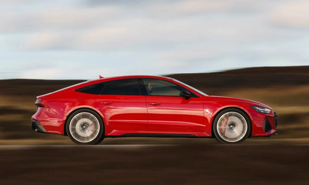 Фото Audi RS7 Sportback — вид сбоку, фото 4. Красный кузов в профиль — пропорции, высота посадки и дизайн дисков. Длинная база — простор второго ряда; короткие свесы упрощают парковку Audi RS7 Sportback — вид сбоку, фото 4