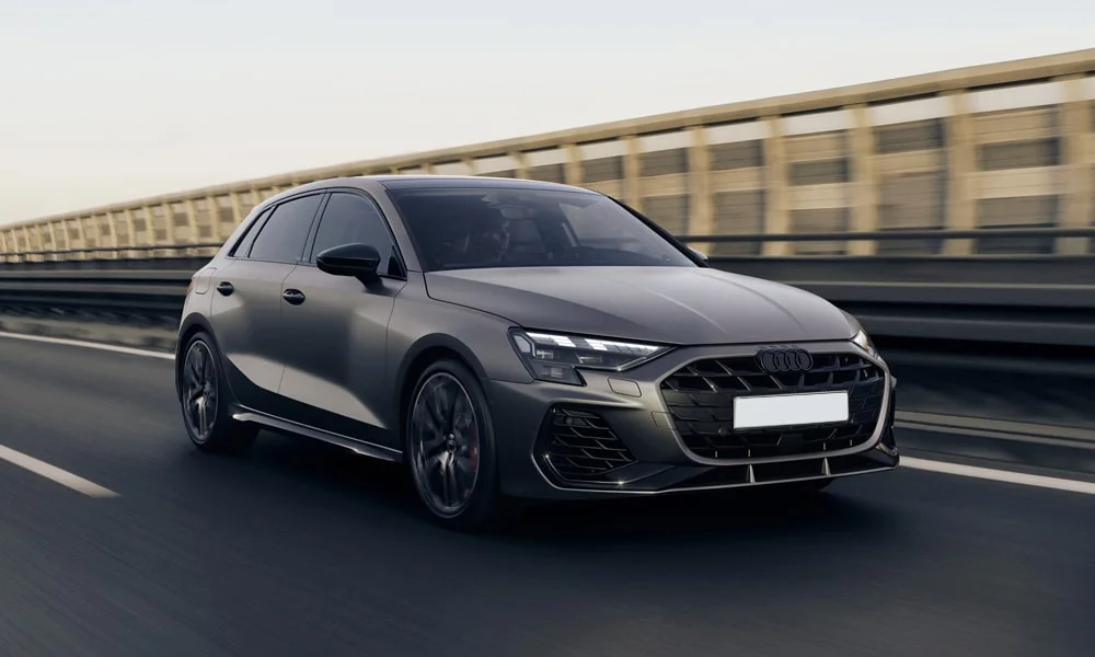 Фото Audi S3 Sportback (2024) — вид спереди, фото 6. Кузов в сером цвете: рисунок оптики и решётки задаёт узнаваемое «лицо» модели. Дневные ходовые огни включаются автоматически с запуском Audi S3 Sportback (2024) — вид спереди, фото 6
