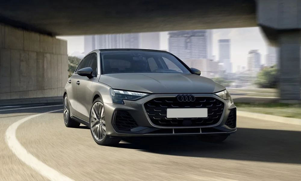 Фото Audi S3 Sportback (2024) — вид спереди, фото 7. Кузов в сером цвете: рисунок оптики и решётки задаёт узнаваемое «лицо» модели. Дневные ходовые огни включаются автоматически с запуском Audi S3 Sportback (2024) — вид спереди, фото 7