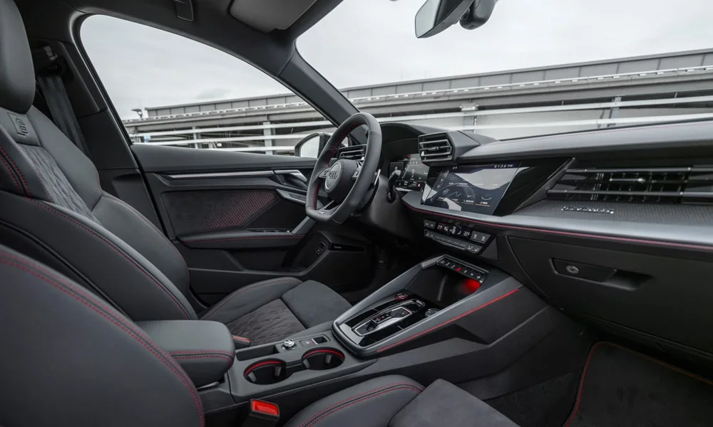 Фото Audi S3 Sportback (2024) — интерьер. Общий план салона: архитектура панели, консоль и кресла. Уровень отделки читается по стыкам панелей и мягким поверхностям в зонах касания Audi S3 Sportback (2024) — интерьер