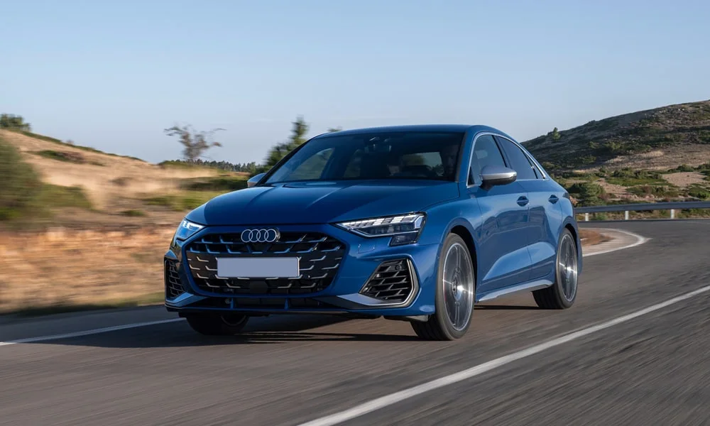 Фото Audi S3 (2024) — вид спереди, фото 4. Синий кузов, строгая симметрия оптики — базовый ракурс знакомства с дизайном. Дневные ходовые огни включаются автоматически с запуском Audi S3 (2024) — вид спереди, фото 4