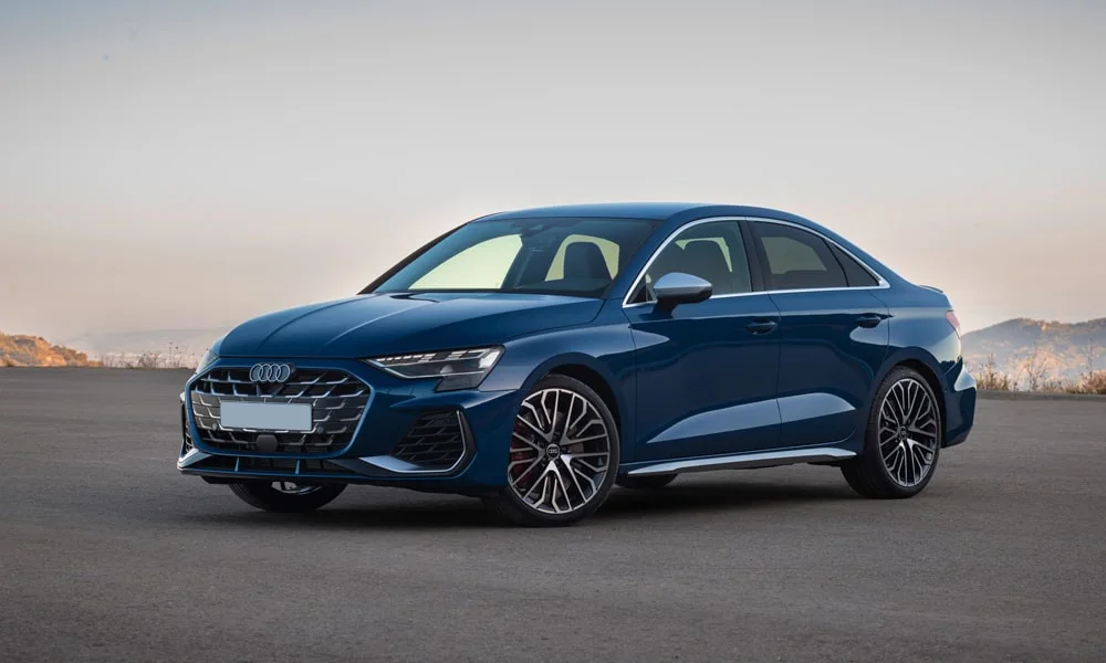 Фото Audi S3 (2024) — вид спереди, фото 9. Синий кузов, строгая симметрия оптики — базовый ракурс знакомства с дизайном. Рисунок ходовых огней — подпись модели, по нему её узнают в потоке Audi S3 (2024) — вид спереди, фото 9