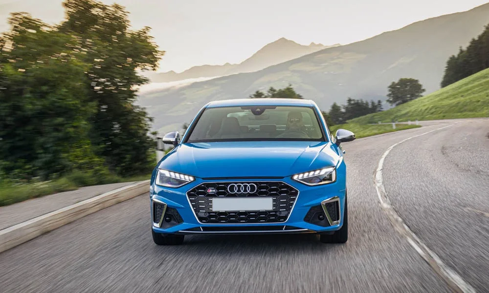 Фото Audi S4 — вид спереди, фото 7. Кузов в синем цвете: рисунок оптики и решётки задаёт узнаваемое «лицо» модели. Рисунок ходовых огней — подпись модели, по нему её узнают в потоке Audi S4 — вид спереди, фото 7