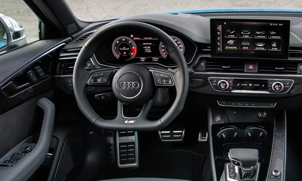 Фото Audi S4 — руль. Обшивка обода и компоновка спиц крупным планом. Клавиши на спицах управляют медиа, круизом и ассистентами — руки остаются на руле Audi S4 — руль