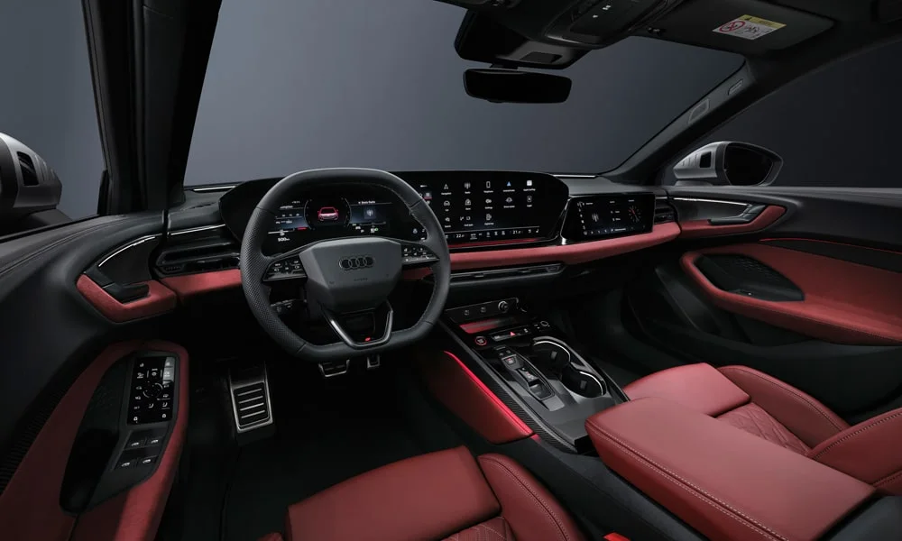 Фото Audi S5 Avant (2024) — передняя панель. Панель в красно-чёрной отделке — видна компоновка экранов и органов управления Audi S5 Avant (2024) — передняя панель