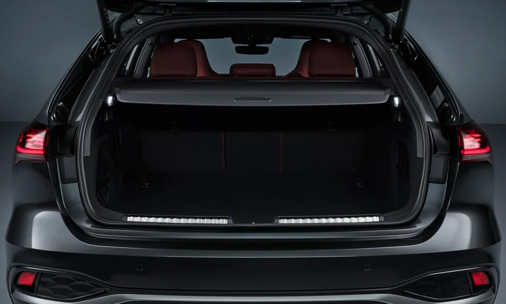 Фото Audi S5 Avant (2024) — багажник. Грузовой отсек с открытой дверью: погрузочная высота и ширина проёма. Электропривод двери с датчиком под бампером — руки заняты, багажник открыт Audi S5 Avant (2024) — багажник