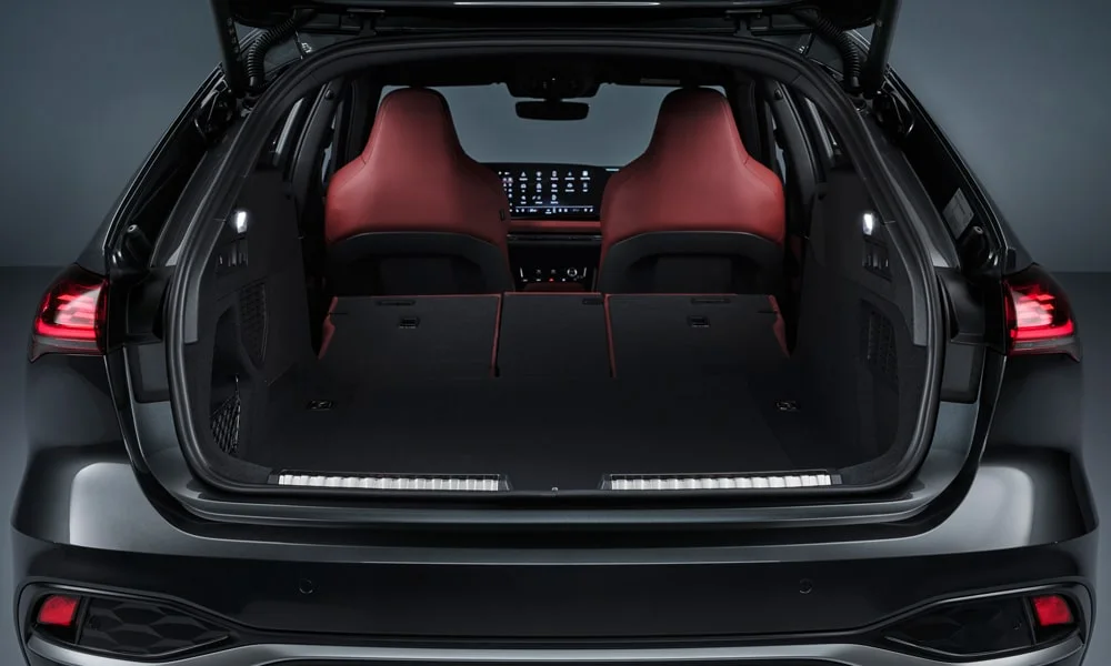 Фото Audi S5 Avant (2024) — багажник, фото 2. Грузовой отсек с открытой дверью: погрузочная высота и ширина проёма. Электропривод двери с датчиком под бампером — руки заняты, багажник открыт Audi S5 Avant (2024) — багажник, фото 2