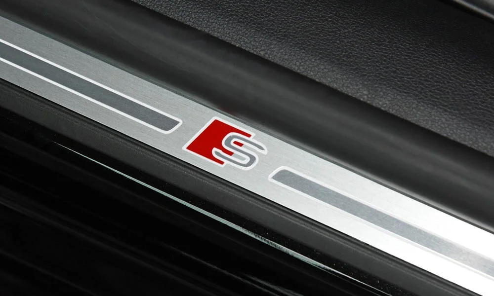 Фото Audi S5 (2024) — дверная карта, фото 2. Подлокотник, динамик и блок стеклоподъёмников. Решётка динамика в двери — часть штатной акустики Audi S5 (2024) — дверная карта, фото 2