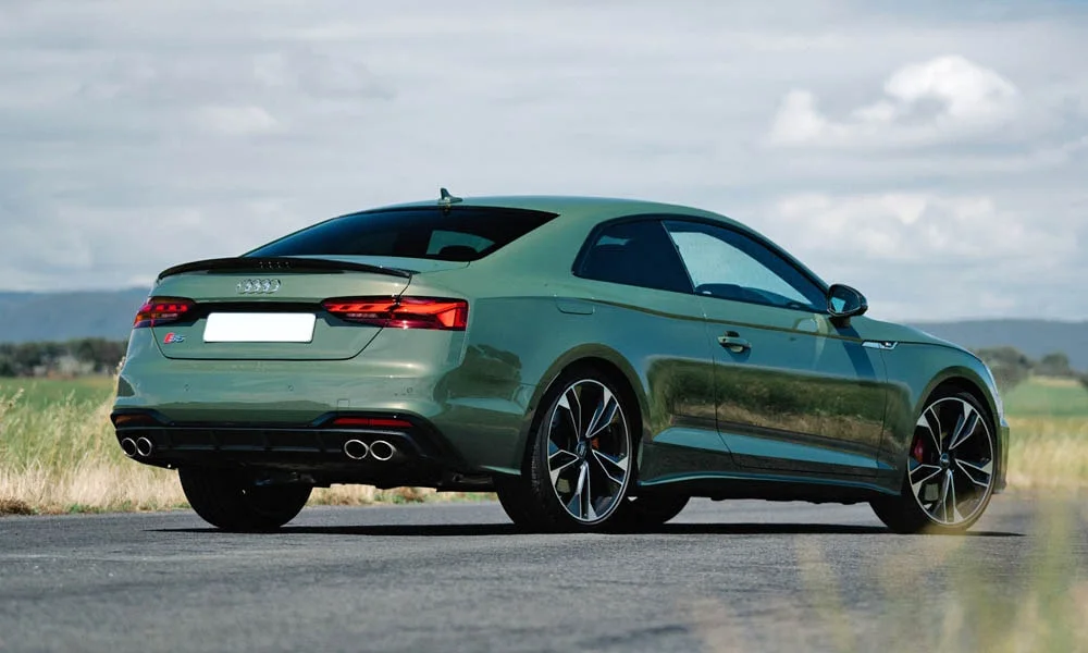 Фото Audi S5 (2024) — вид сзади, фото 16. Корма в зелёном цвете: графика фонарей и пластика пятой двери. Насадки выхлопа или их имитация внизу бампера различают версии Audi S5 (2024) — вид сзади, фото 16