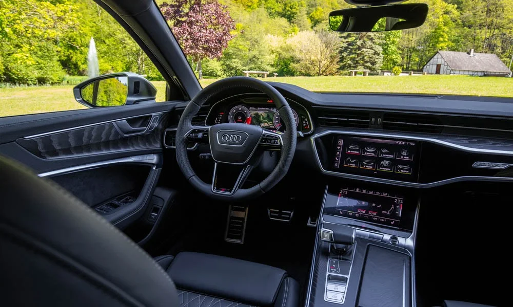 Фото Audi S6 — руль. Обшивка обода и компоновка спиц крупным планом. Клавиши на спицах управляют медиа, круизом и ассистентами — руки остаются на руле Audi S6 — руль