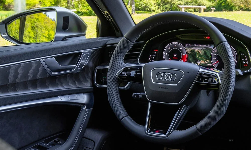 Фото Audi S6 — руль, фото 2. Обшивка обода и компоновка спиц крупным планом. Клавиши на спицах управляют медиа, круизом и ассистентами — руки остаются на руле Audi S6 — руль, фото 2