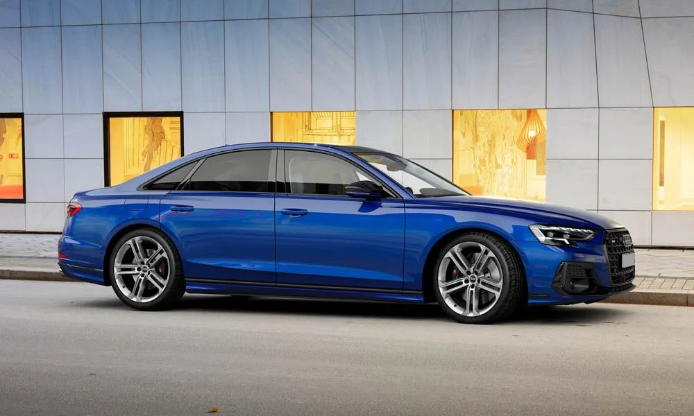 Фото Audi S8 (2024) — вид спереди, фото 10. Синий кузов, строгая симметрия оптики — базовый ракурс знакомства с дизайном. Дневные ходовые огни включаются автоматически с запуском Audi S8 (2024) — вид спереди, фото 10