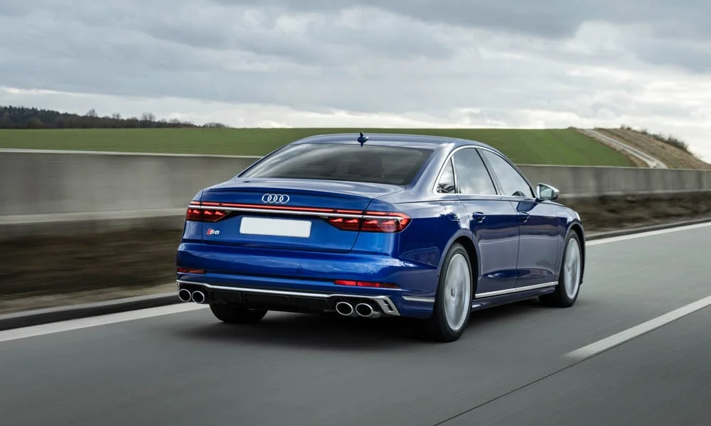 Фото Audi S8 (2024) — вид сзади, фото 3. Линия крыши, стойки и задняя дверь в синем исполнении. Светодиодная полоса или раздельные секции — задняя оптика стала главным украшением кормы Audi S8 (2024) — вид сзади, фото 3