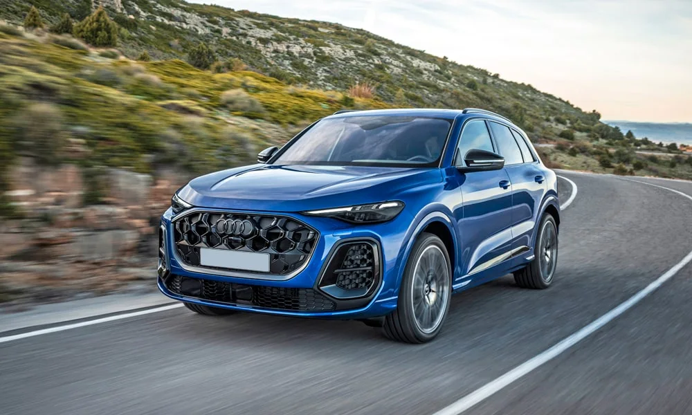 Фото Audi SQ5 (2024) — вид спереди, фото 5. Синий кузов, строгая симметрия оптики — базовый ракурс знакомства с дизайном. Дневные ходовые огни включаются автоматически с запуском Audi SQ5 (2024) — вид спереди, фото 5