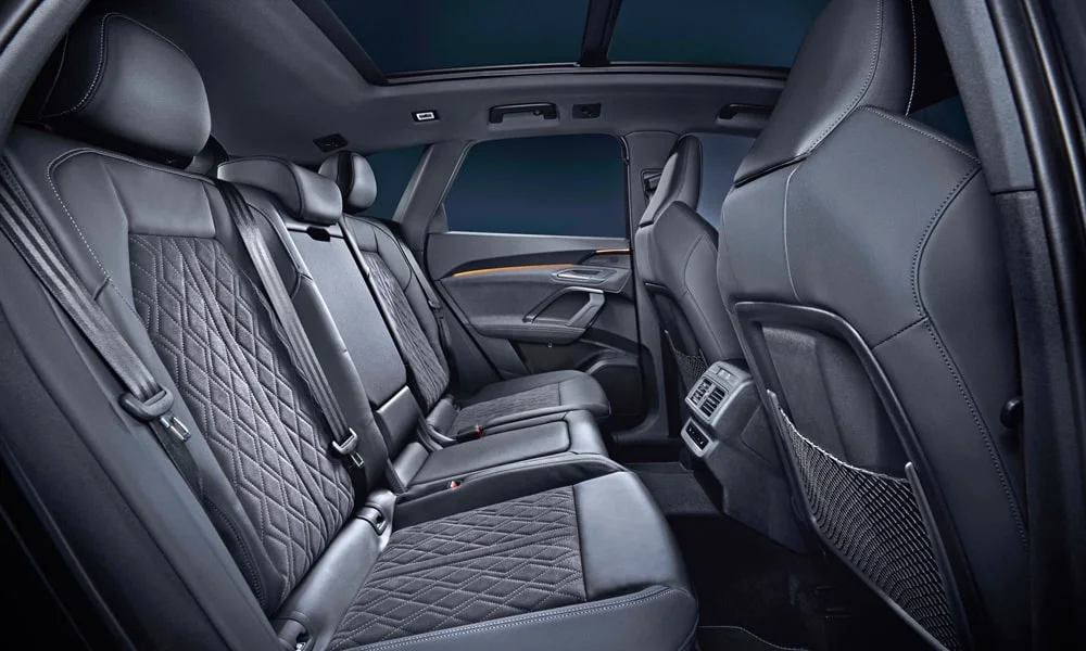 Фото Audi SQ5 (2024) — задние сиденья. Посадка второго ряда: подголовники и подлокотник. Крепления ISOFIX для детских кресел — в основании спинки Audi SQ5 (2024) — задние сиденья