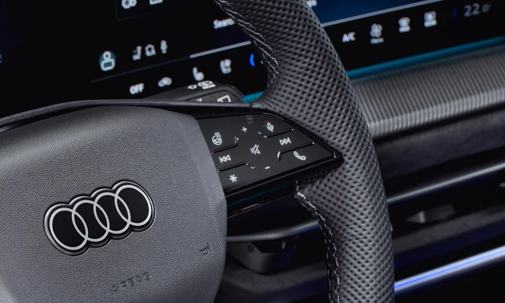 Фото Audi SQ5 (2024) — руль, фото 3. Обшивка обода и компоновка спиц крупным планом. Клавиши на спицах управляют медиа, круизом и ассистентами — руки остаются на руле Audi SQ5 (2024) — руль, фото 3